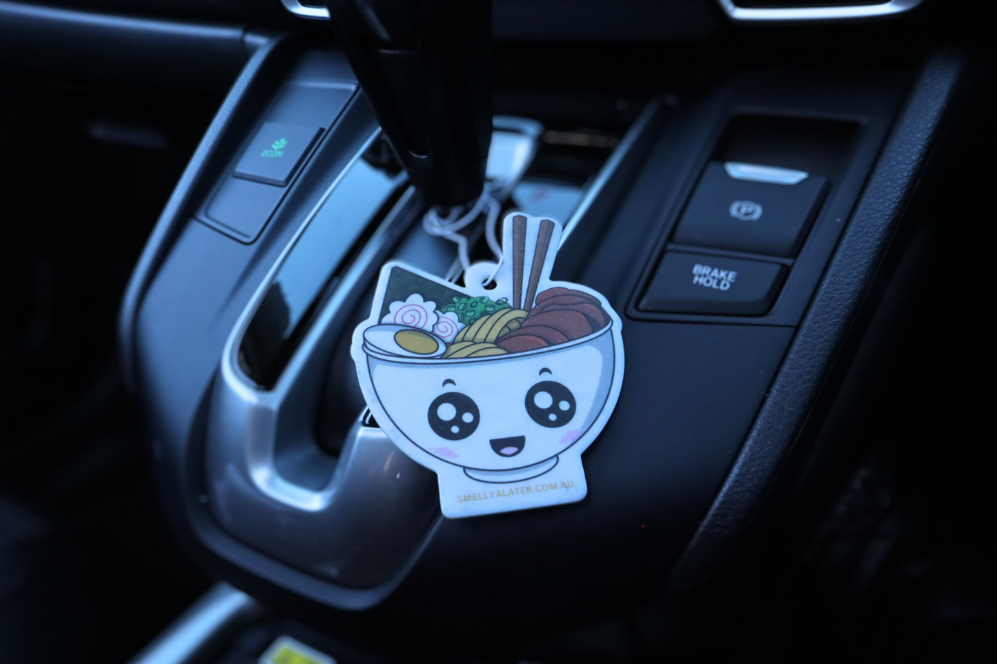 Cute, smiling, blushing tasty ramen with boiled egg, yellow thick noodles, tasty meat, spring onions, seaweed, fish cake and big sparkling eyes, hung in a cool black interior car. Smell Ya Later - Scented Air Freshener. Suitable for homes, wardrobes, cupboards, bathrooms, cars, office space, pet rooms, bed rooms, kitchen.