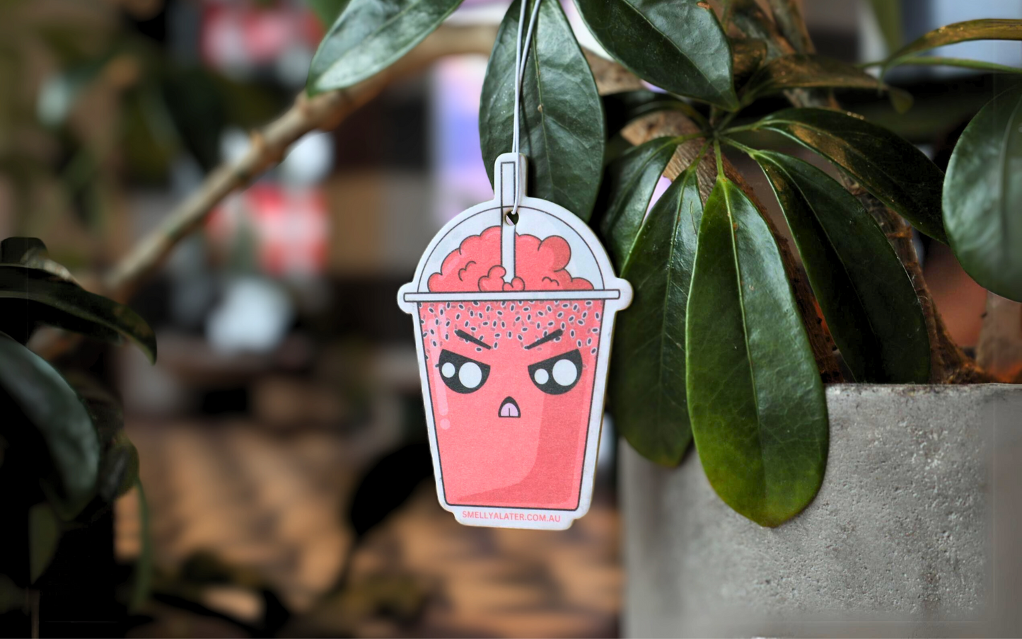 Cute, angry red boba/bubble tea with chia seeds, red bubbly froth and big sparkling eyes, hanging on beautiful green plants. Smell Ya Later - Scented Air Freshener. Suitable for homes, wardrobes, cupboards, bathrooms, cars, office space, pet rooms, bed rooms, kitchen.